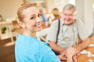 Happy,Nursing,Woman,On,A,Home,Visit,Comforts,A,Senior